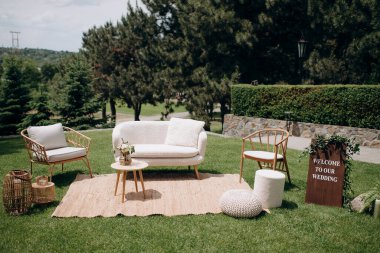 Yeşil çimenlikte hoş geldin tabelası olan zarif bir düğün salonu.