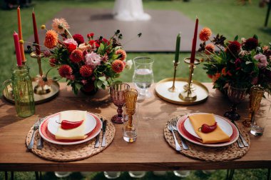 Renkli çiçekler ve tabakta kırmızı biberli kırsal açık hava masası.