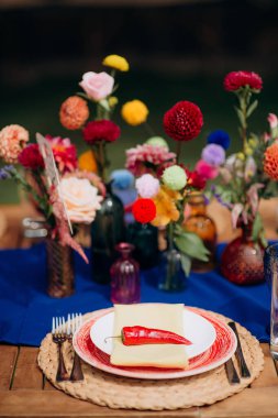 Kırmızı biberli, sarı peçeteli kırsal açık hava mekanı.