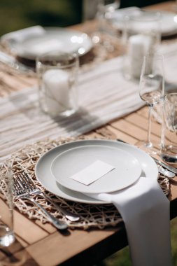 Küçük vazolarda beyaz çiçekler olan şık bir açık hava masası.