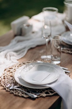 Küçük vazolarda beyaz çiçekler olan şık bir açık hava masası.