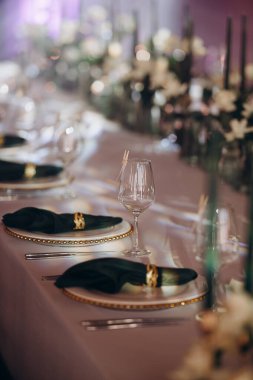 Sahne ışıkları altında altın ve yeşil renkli şık bir ziyafet masası.