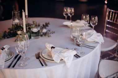 Beyaz ve yeşil elementlerle donatılmış şık bir düğün masası.