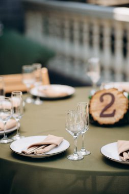 Yeşil masa örtüsü, beyaz tabaklar ve yosun merkezli şık bir masa örtüsü.