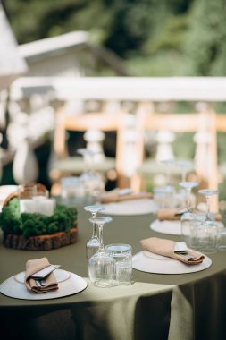 Yeşil masa örtüsü, beyaz tabaklar ve yosun merkezli şık bir masa örtüsü.