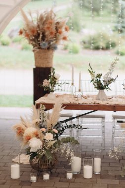 Pampa otları, kurumuş çiçekler ve sicim ışıkları olan bir çadırda zarif bir boho düğünü.