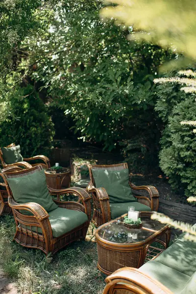 Masası, sandalyeleri ve bitkileri olan rahat bir açık hava salonu.