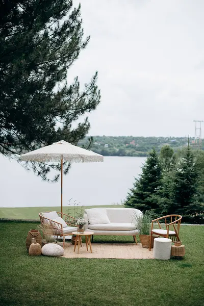 Şemsiyeli ve su manzaralı şık bir açık hava salonu.