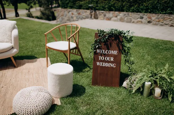 Hoş geldin tabelası ve yumuşak koltuklu rahat bir düğün salonu.