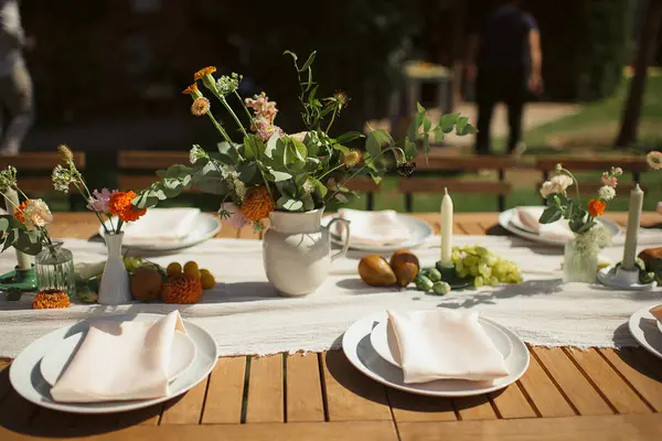 Açık bej bir çalıştırıcı ve basit beyaz plakalı kırsal açık masa ayarları