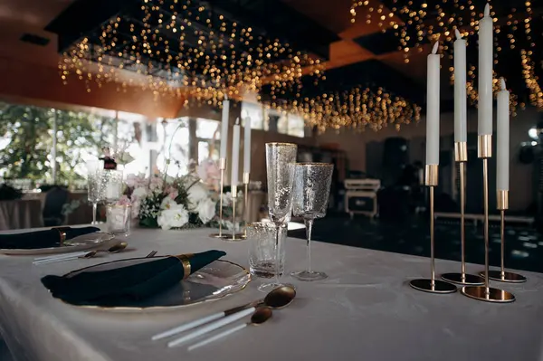 Peri ışıklarıyla süslenmiş, altın ve yeşille süslü şık bir masa.