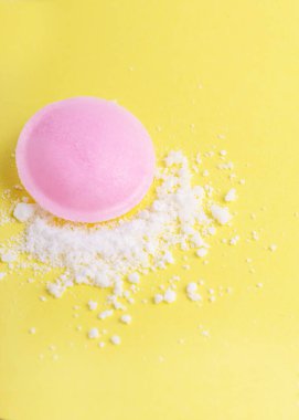  Sarı arka planda şerbetle çevrili pembe bir uçan daire, minimalist ve canlı bir kompozisyon oluşturuyor..