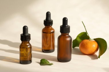 Koyu cam şişelerde C vitamini serumları, seçici odaklanma. Gölgeler ve güneş ışığı