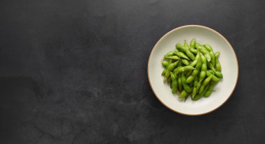 Siyah arkaplanda Edamame fasulyesi, Asya yemeği, üst görünüm, boşluk kopyala