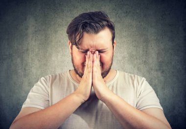 Dua eden üzgün, çaresiz bir adamın yakın plan portresi 