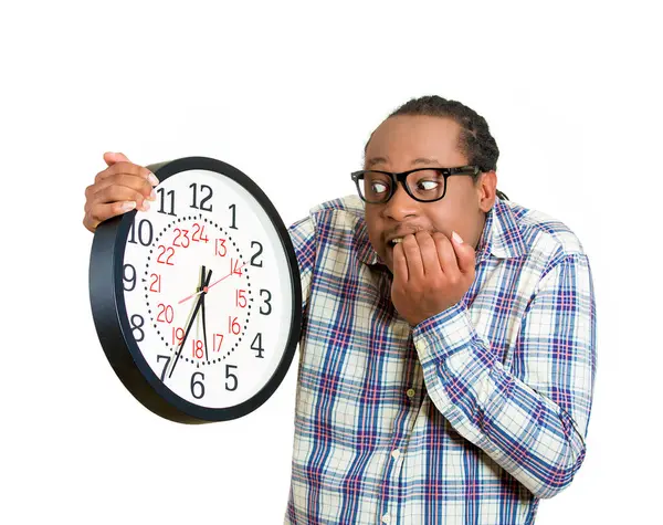 stock image Stressed young man running out of time looking at wall clock