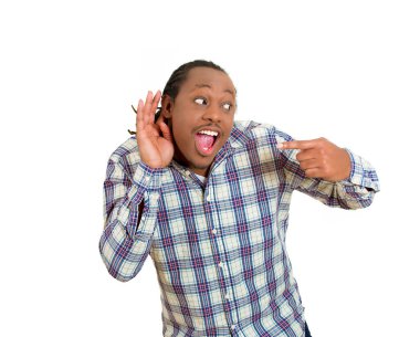 Şaşırmış genç adam elini kulağının dibinde tutuyor ve dikkatlice dinliyor. 