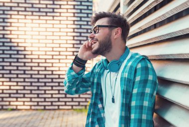 Dışarıda dikilen ve cep telefonuyla konuşan mutlu adam..