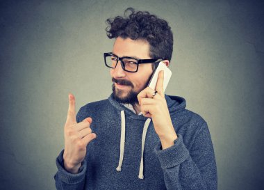 Yüzünde aldatıcı bir ifade olan bir adam telefonla konuşuyor. 