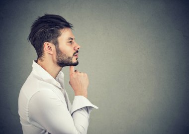 El pençe divan duran bir iş adamının yan profili. Düşünceli yüz ifadesi olan bir soruyu düşünüyor.