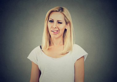 Yaramaz sarışın genç kadın kameraya dilini sokuyor.