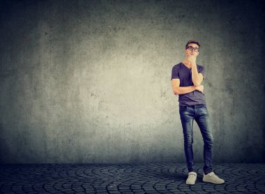 Genç ve ciddi bir adam yukarı bakıyor.