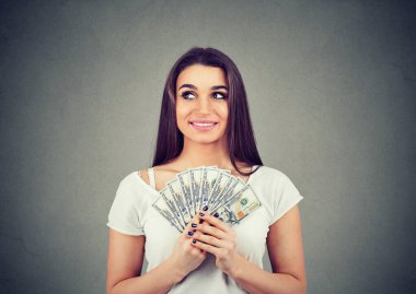 Dolar banknotları olan, mali özgürlüğü düşünen sevimli, gülümseyen bir kadın.