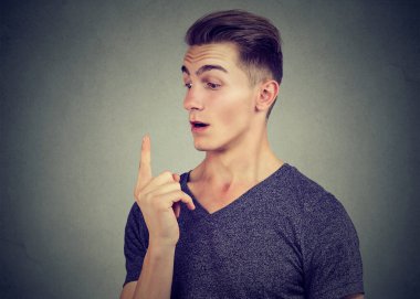 İşaret parmağına bakan şaşırmış bir adamın portresi.