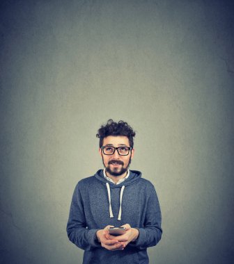 Cep telefonlu bir adam yukarı bakıyor. 