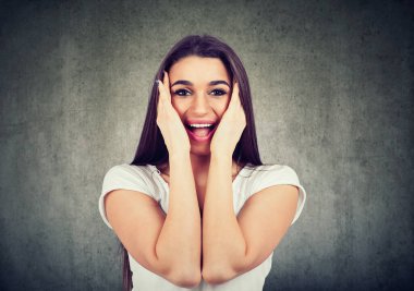 Mutlu, sevimli, güzel bir kadının portresi. Heyecanlı görünüyor, tamamen inançsız, elleri yanaklarında. 