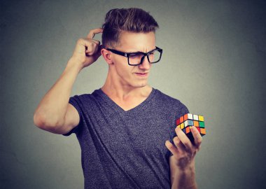 Rubiks küpünü tutan genç adam bir göreve odaklanmış..