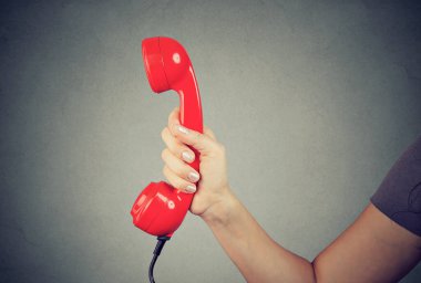 Bir adamın el ele tutuşması ve kırmızı telefon ahizesini göstermesi..