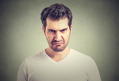 Closeup portrait of an angry grumpy young man  clipart