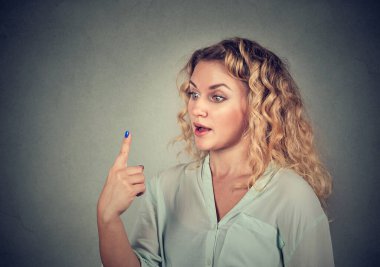 Şok olmuş genç bir kadın işaret parmağına bakıyor.