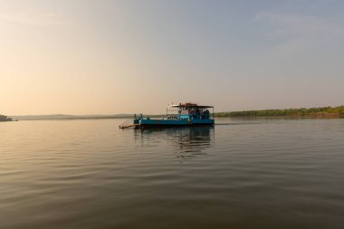 ferry crossing the mandovi river at dusk to help in transportation of vehicles, people and goods to the Divar island in Goa, India.
