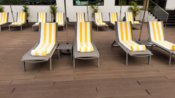 Pool chairs or sun loungers arranged neatly on a pool deck.