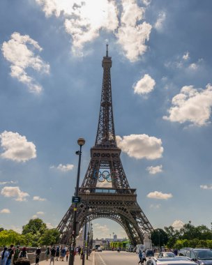 Paris, Fransa - 24 Haziran 2024: Olimpiyat yüzüklü Eyfel kulesinin Seine nehri üzerindeki bir köprüden görünüşü.