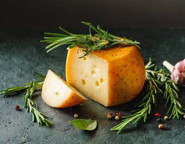 Koyu arkaplanda Gouda peyniri. Bu resim yapay zekayla oluşturuldu ve bir referans resmi kullanıldı.