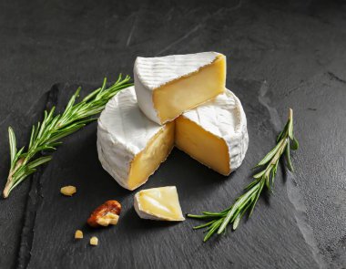 Koyu arkaplanda Camembert peyniri. Bu resim yapay zekayla oluşturuldu ve bir referans resmi kullanıldı.