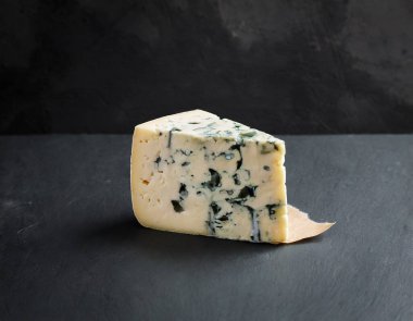 Koyu arkaplanda mavi peynir. Bu resim yapay zekayla oluşturuldu ve bir referans resmi kullanıldı.