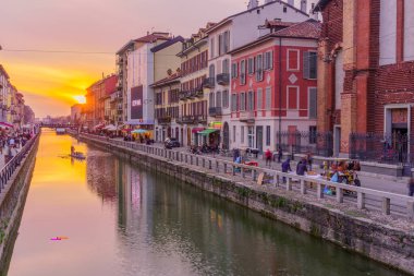 Milan, İtalya - 02 Mart 2022: Naviglio Grande kanalının Navigli, Milan, Lombardy, Kuzey İtalya 'da yerel halk ve ziyaretçilerle gün batımı manzarası