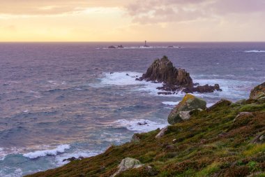 İngiltere, Cornwall 'da bulunan Longships Lighthouse ile Lands End kıyı şeridi manzarasının günbatımı