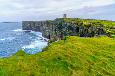 Marwick Head, Mainland Orkney, İskoçya, İngiltere 'deki sahil kayalıkları ve Kitchener Anıtı manzarası