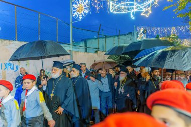 Nazareth, Israel - January 06, 2023: Orthodox Christmas Eve parade, with the patriarch, participants, and crowd, in Nazareth, Israel