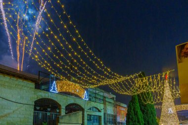 Nazareth, Israel - January 06, 2023: Fireworks and Christmas tree in the church (Mary well) square, on Orthodox Christmas Eve, in Nazareth, Israel