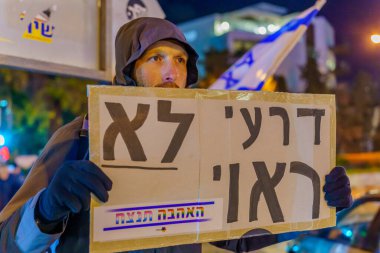 Haifa, Israel - January 14, 2023: People protest with signs against the corruption of the new government, in Haifa, Israel