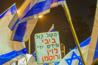 Haifa, Israel - January 28, 2023: Various signs and flags raised during a demonstration in protest against the plans of the new government, claiming its anti-democratic, in Haifa, Israel