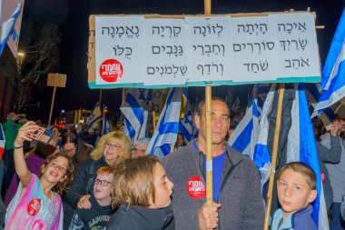 Hayfa, İsrail - 11 Mart 2023: Çeşitli tabela ve bayraklı protestocular, İsrail 'in Hayfa kentinde anti-demokratik olduğunu iddia eden yeni hükümetin planlarına karşı düzenlenen gösteriye katıldılar.