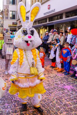 Lucerne, İsviçre - 21 Şubat 2023: Kostüm giymiş bir grup katılımcı ve kalabalık, İsviçre 'nin Lucerne kentinde düzenlenen Fasnacht Karnavalı' nın çocuk geçit töreninin bir parçası.