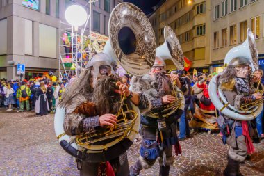 Lucerne, İsviçre - 21 Şubat 2023: Fasnacht Karnavalı 'nın son gecesinde İsviçre' nin Lucerne şehrinde kostümlü müzisyenler yürüyüşe geçti